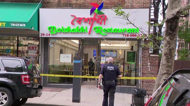 Crime scene tape blocks off the sidewalk outside a restaurant in Queens. 